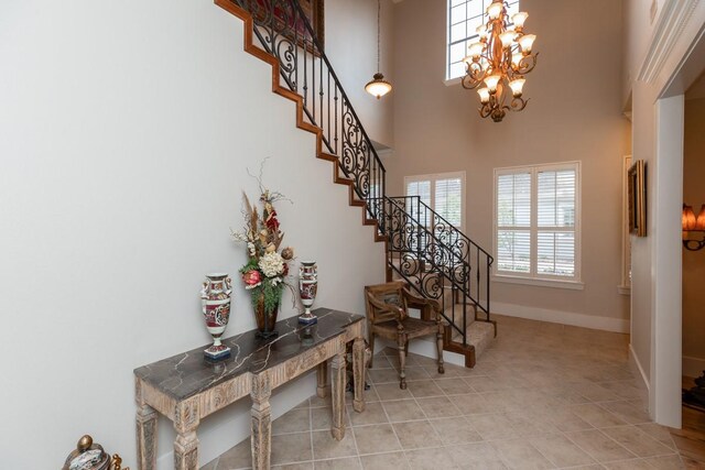5950 Keith Rd, Lumberton, TX 77657 - stairway featuring plenty of natural light, a chandelier, baseboards, tile patterned floors, and a high ceiling