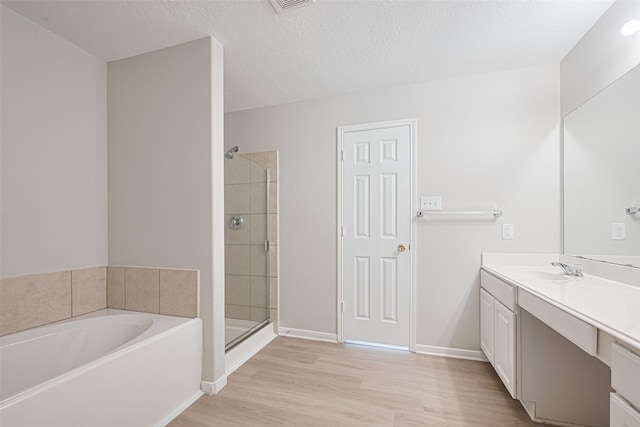1219 Newsome Glenn Dr, Houston, TX 77090 - bathroom featuring vanity, a bath, a stall shower, wood finished floors, and baseboards