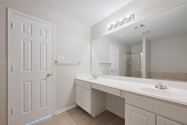 1219 Newsome Glenn Dr, Houston, TX 77090 - full bathroom with double vanity, wood finished floors, a shower stall, and baseboards