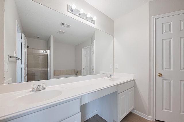 1219 Newsome Glenn Dr, Houston, TX 77090 - full bathroom with double vanity, a stall shower, wood finished floors, and a tub to relax in
