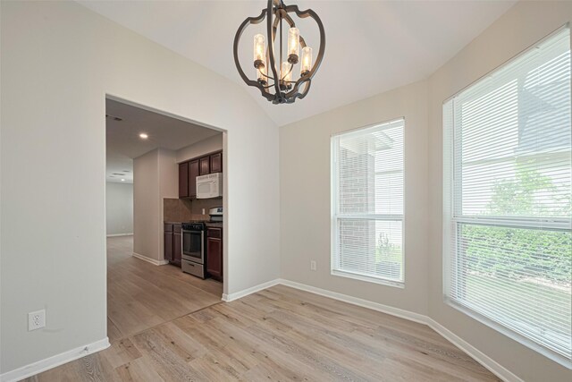 1219 Newsome Glenn Dr, Houston, TX 77090 - unfurnished dining area with a chandelier, light wood-style floors, baseboards, and vaulted ceiling
