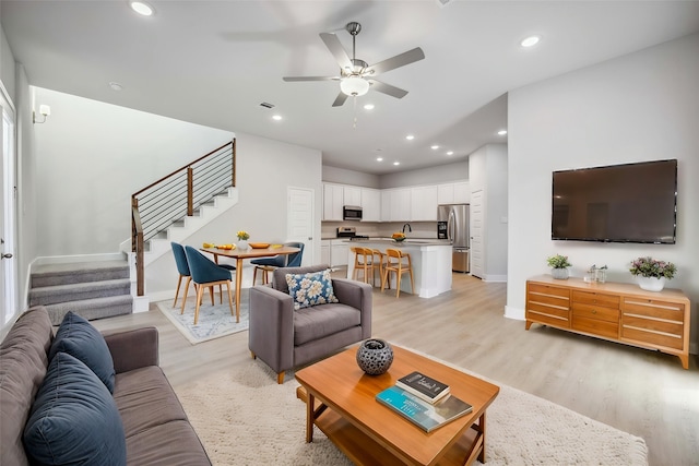 13424 Sun Cay Dr, Houston, TX 77047 - living area with stairway, baseboards, a ceiling fan, light wood-type flooring, and recessed lighting