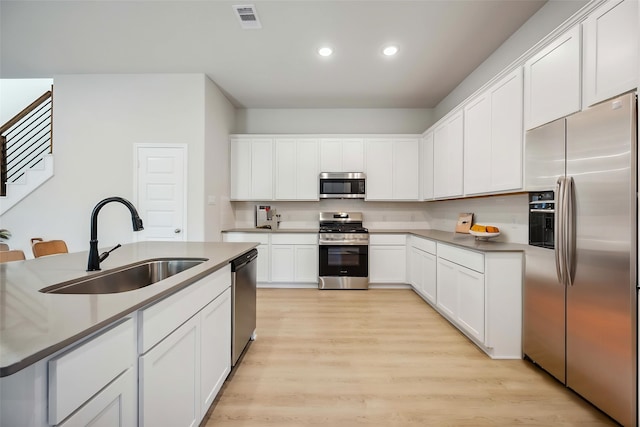 13424 Sun Cay Dr, Houston, TX 77047 - kitchen featuring stainless steel appliances, a sink, recessed lighting, light wood-type flooring, and white cabinetry