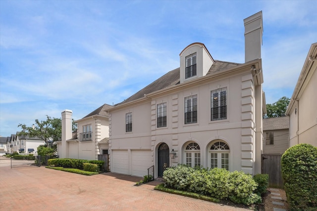 2214 Potomac Dr Unit 2, Houston, TX 77057 - view of front facade with a chimney, an attached garage, decorative driveway, and stucco siding