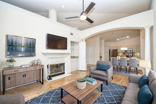 2100 Welch St Unit C305, Houston, TX 77019 - living room featuring ornate columns, ceiling fan, light wood finished floors, arched walkways, and lofted ceiling