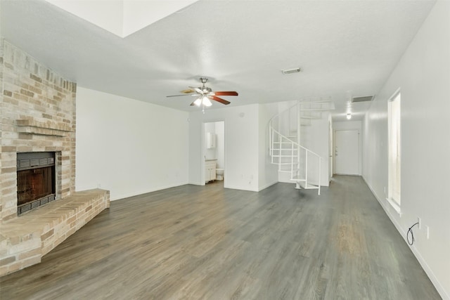 2079 Country Village Blvd Unit C, Humble, TX 77338 - unfurnished living room with stairs, wood finished floors, a fireplace, a ceiling fan, and baseboards