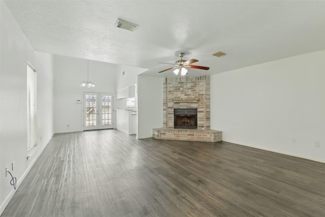 2079 Country Village Blvd Unit C, Humble, TX 77338 - unfurnished living room featuring a ceiling fan, wood finished floors, a fireplace, a textured ceiling, and a chandelier