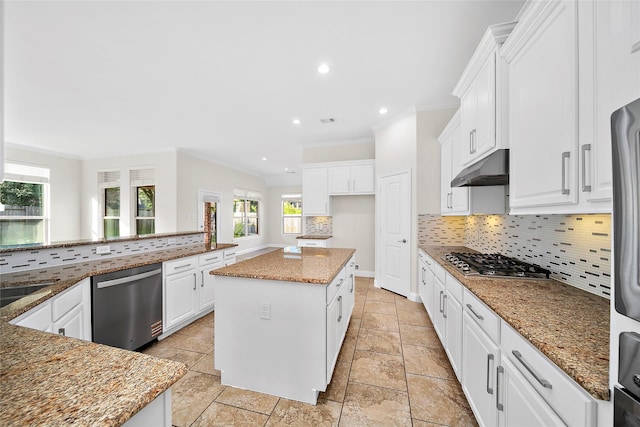 27910 Wedgeoak Ct, Katy, TX 77494 - kitchen with appliances with stainless steel finishes, under cabinet range hood, decorative backsplash, crown molding, and white cabinetry