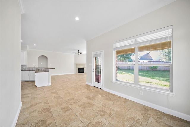 27910 Wedgeoak Ct, Katy, TX 77494 - unfurnished living room with a fireplace, baseboards, a ceiling fan, arched walkways, and recessed lighting