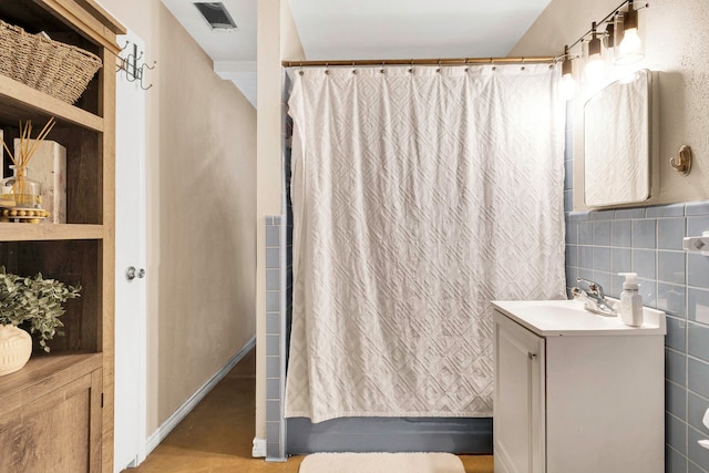 111 W Limit St, Madisonville, TX 77864 - bathroom with vanity, shower / bath combo with shower curtain, and tile walls