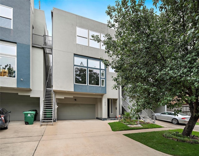 1822 Brun St, Houston, TX 77019 - view of front facade with stairs, a garage, concrete driveway, and stucco siding
