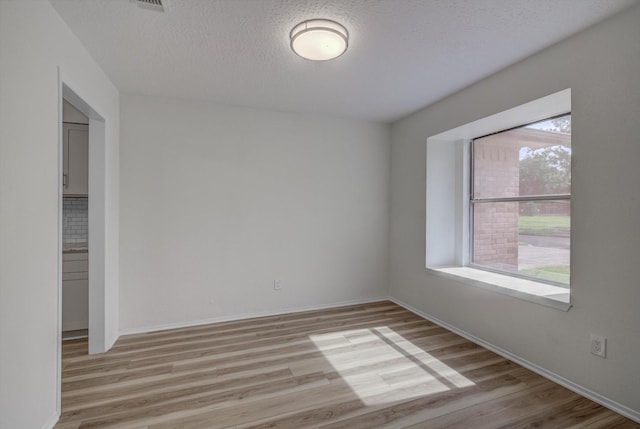 1041 Crossing Rd, Angleton, TX 77515 - spare room with light wood-style floors and a textured ceiling