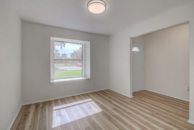 1041 Crossing Rd, Angleton, TX 77515 - unfurnished room with light wood-style flooring and a textured ceiling