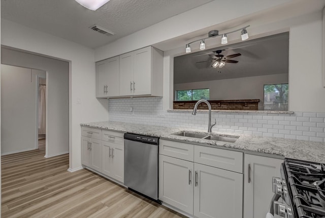 1041 Crossing Rd, Angleton, TX 77515 - kitchen featuring stainless steel appliances, backsplash, light wood finished floors, ceiling fan, and light stone countertops