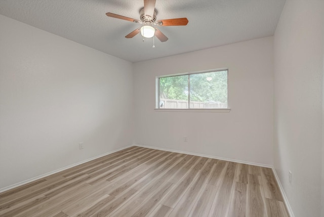 1041 Crossing Rd, Angleton, TX 77515 - empty room with light wood finished floors, a ceiling fan, and a textured ceiling
