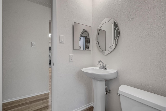 1041 Crossing Rd, Angleton, TX 77515 - half bath featuring toilet and wood finished floors