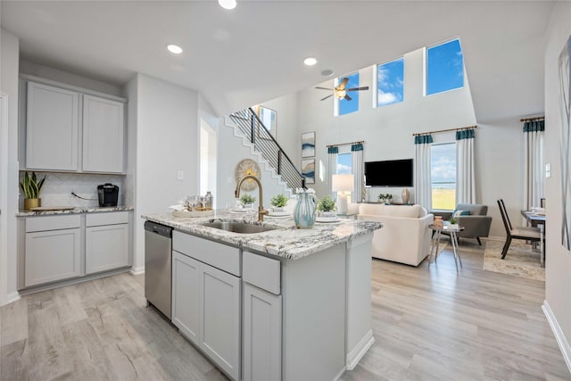 11745 Whirlaway Dr, Willis, TX 77318 - kitchen with stainless steel dishwasher, a sink, a ceiling fan, light wood-style flooring, and recessed lighting