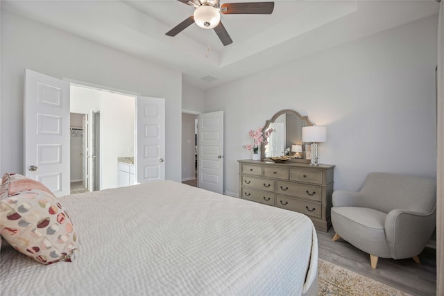 11745 Whirlaway Dr, Willis, TX 77318 - bedroom featuring a spacious closet, a ceiling fan, light wood finished floors, a raised ceiling, and a closet