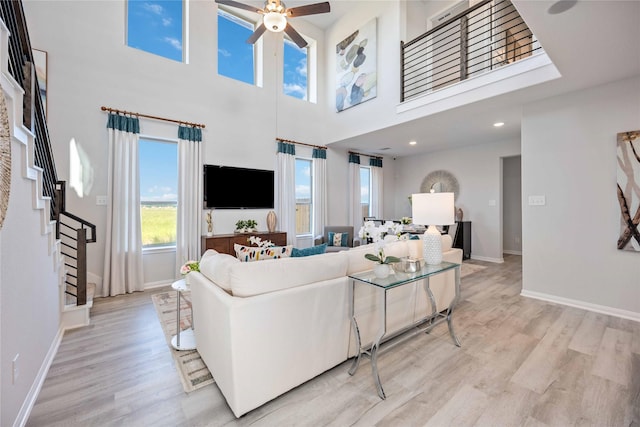 11745 Whirlaway Dr, Willis, TX 77318 - living room with a ceiling fan, light wood-type flooring, baseboards, and a high ceiling