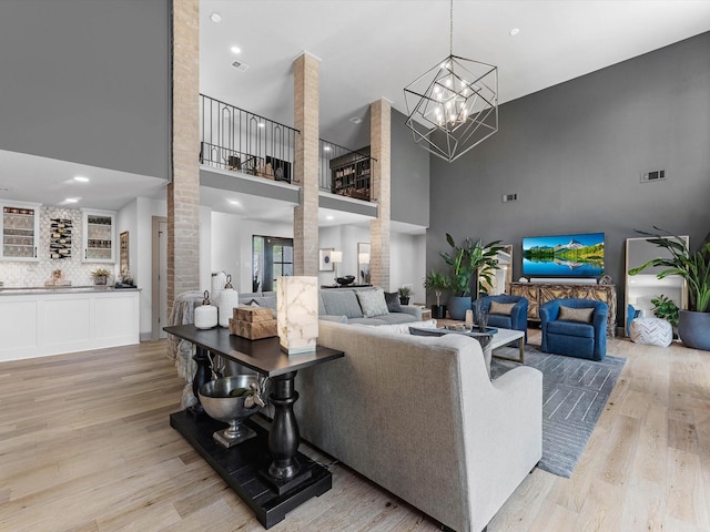 15722 Island Grove Ct, Houston, TX 77079 - living room featuring a high ceiling, light wood finished floors, and a chandelier