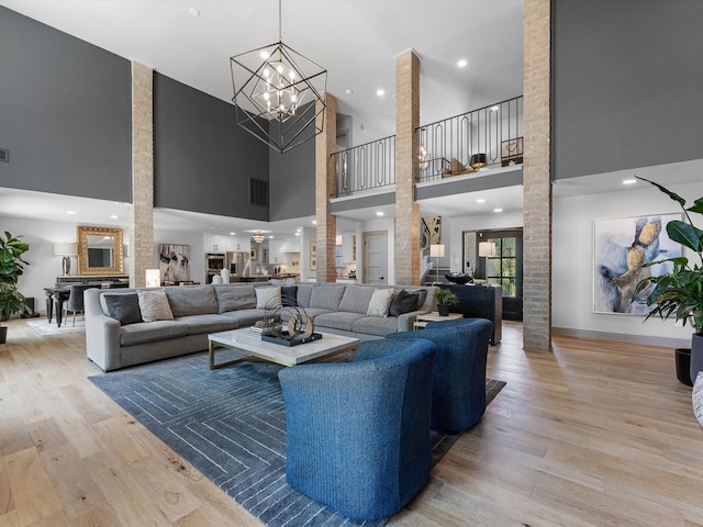 15722 Island Grove Ct, Houston, TX 77079 - living area with a high ceiling, light wood-style flooring, decorative columns, and a chandelier