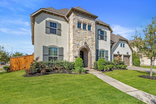 5807 Yango Terrace Ln, Sugar Land, TX 77479 - french country home with stone siding, driveway, a front lawn, and a shingled roof