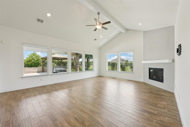 25306 Hollowgate Park Ln, Tomball, TX 77375 - unfurnished living room with beamed ceiling, a ceiling fan, wood finished floors, a large fireplace, and high vaulted ceiling