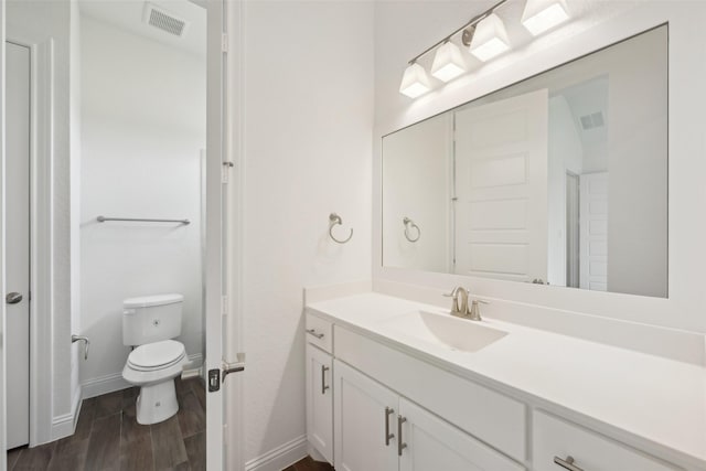 25306 Hollowgate Park Ln, Tomball, TX 77375 - bathroom with vanity, baseboards, wood finished floors, and toilet