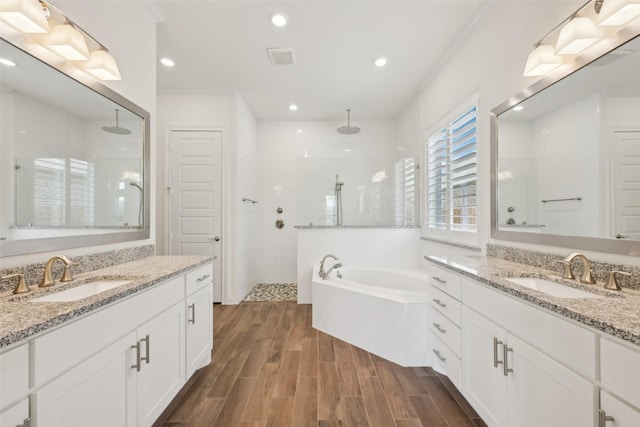 25306 Hollowgate Park Ln, Tomball, TX 77375 - full bathroom with walk in shower, wood finished floors, a garden tub, two vanities, and recessed lighting