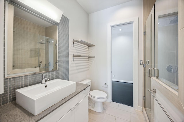 207 Pierce St Unit 205, Houston, TX 77002 - full bathroom featuring vanity, a shower stall, tile walls, toilet, and tile patterned floors