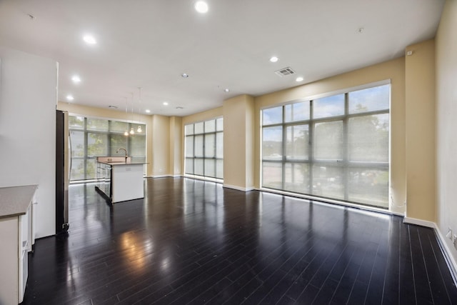 207 Pierce St Unit 205, Houston, TX 77002 - unfurnished living room with dark wood-style flooring, recessed lighting, baseboards, and a sink