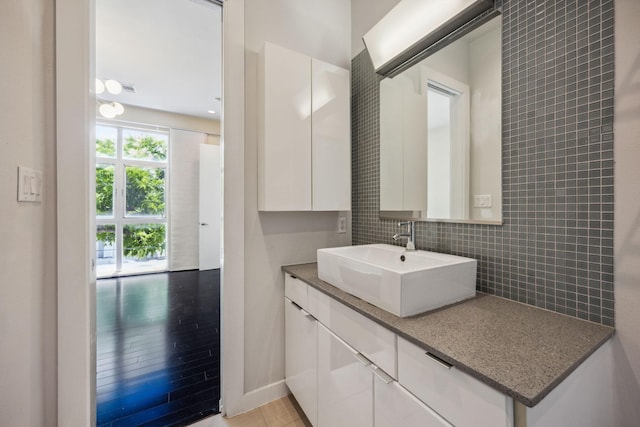 207 Pierce St Unit 205, Houston, TX 77002 - bathroom with vanity, decorative backsplash, and wood finished floors