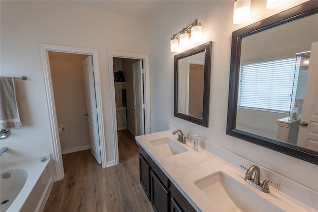 3017 Cambridge Meadows Ln, Dickinson, TX 77539 - bathroom with wood finished floors, double vanity, a bath, and baseboards