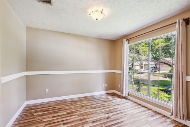 19 Almond Branch Pl, The Woodlands, TX 77382 - spare room featuring wood finished floors, a textured ceiling, and baseboards
