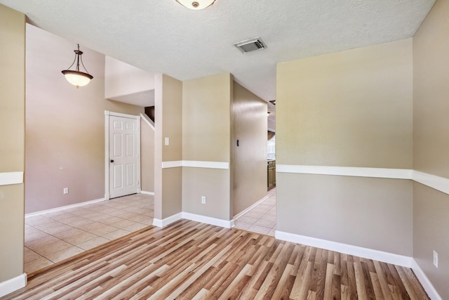 19 Almond Branch Pl, The Woodlands, TX 77382 - empty room featuring wood finished floors, a textured ceiling, and baseboards