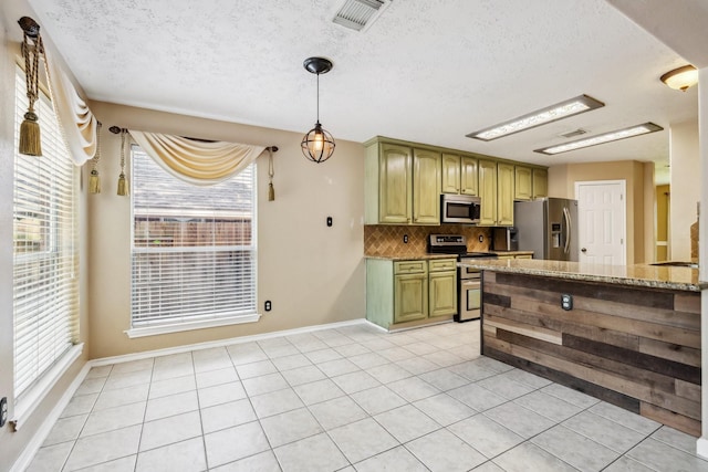 19 Almond Branch Pl, The Woodlands, TX 77382 - kitchen with stainless steel appliances, decorative backsplash, a textured ceiling, light stone counters, and light tile patterned floors