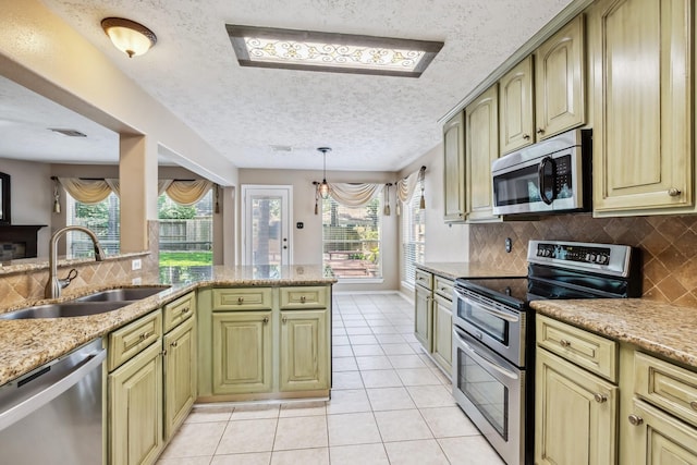 19 Almond Branch Pl, The Woodlands, TX 77382 - kitchen featuring appliances with stainless steel finishes, a sink, backsplash, light tile patterned floors, and healthy amount of natural light
