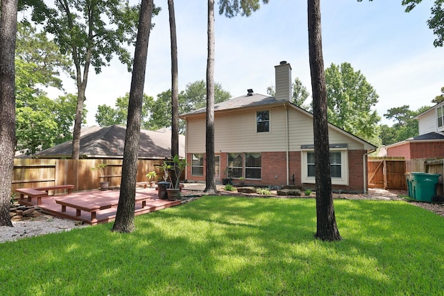 19 Almond Branch Pl, The Woodlands, TX 77382 - rear view of house featuring a wooden deck, brick siding, and a chimney