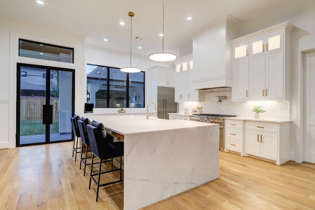 830 Azalea St, Houston, TX 77018 - kitchen featuring high end appliances, custom exhaust hood, light wood-style flooring, tasteful backsplash, and a large island