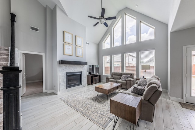 5106 Green Leaf Ln, Fulshear, TX 77441 - living area featuring high vaulted ceiling, a glass covered fireplace, light wood finished floors, ceiling fan, and baseboards