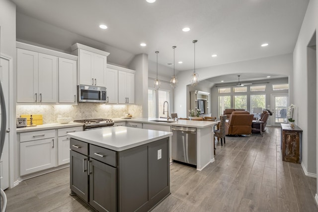229 N Bearkat Ct, Montgomery, TX 77316 - kitchen featuring stainless steel appliances, a center island, a peninsula, arched walkways, and healthy amount of natural light