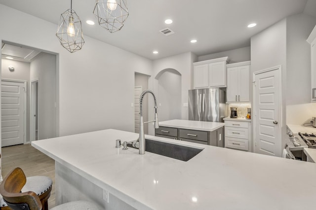229 N Bearkat Ct, Montgomery, TX 77316 - kitchen with freestanding refrigerator, a sink, recessed lighting, light wood-style flooring, and white cabinets