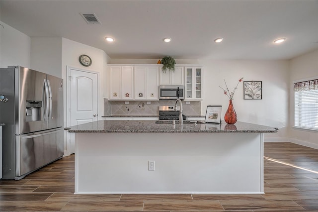 11202 Bluewater Lagoon Cir, Cypress, TX 77433 - kitchen with stainless steel appliances, a sink, dark stone counters, dark wood-type flooring, and recessed lighting
