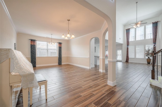 11202 Bluewater Lagoon Cir, Cypress, TX 77433 - unfurnished living room with arched walkways, a chandelier, crown molding, wood finished floors, and baseboards