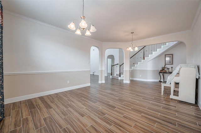 11202 Bluewater Lagoon Cir, Cypress, TX 77433 - empty room featuring arched walkways, a chandelier, stairs, baseboards, and wood finished floors