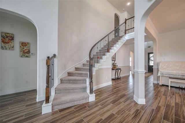 11202 Bluewater Lagoon Cir, Cypress, TX 77433 - entryway with wood finished floors, baseboards, arched walkways, stairway, and a towering ceiling