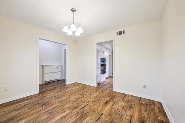 507 Williamsport St, League City, TX 77573 - empty room featuring a chandelier, wood finished floors, and baseboards