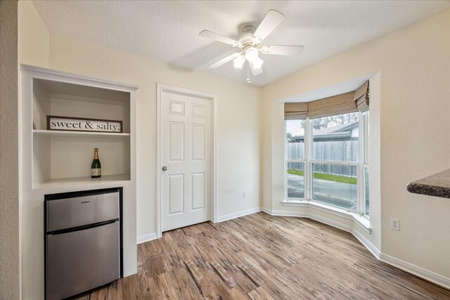 507 Williamsport St, League City, TX 77573 - unfurnished dining area featuring wood finished floors, a dry bar, and baseboards