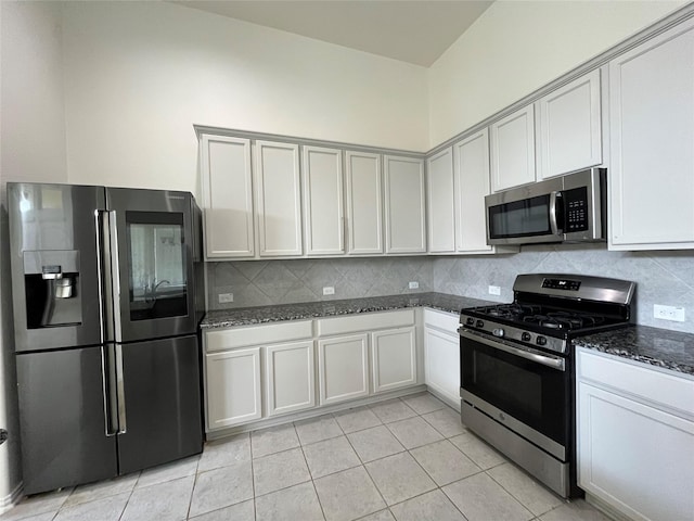 31909 Mckinley Run Dr, Hockley, TX 77447 - kitchen with appliances with stainless steel finishes, decorative backsplash, dark stone countertops, and light tile patterned flooring