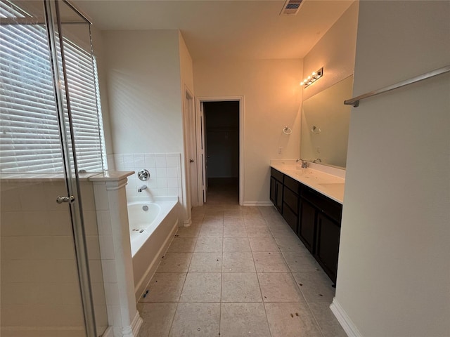 31909 Mckinley Run Dr, Hockley, TX 77447 - full bathroom featuring a bath, double vanity, a shower stall, tile patterned floors, and baseboards